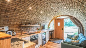 Une cuisine compacte avec un plafond en briques, des plans de travail en bois et un coin repas offrant une vue agréable.