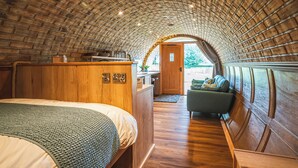 Une pièce chaleureuse aux murs de briques, comprenant un lit, un canapé et un petit coin cuisine.