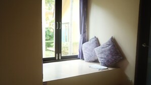 A room with a window seat featuring two patterned cushions and a small table. - Samui Tonggad Resort (Koh Samui)
