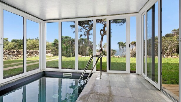 A modern indoor swimming pool with large windows and a view of the outdoors. - Holiday Home "Rocha do Mar 1" with Sea View, Shared Pool & Wi-Fi (Biscoitos)