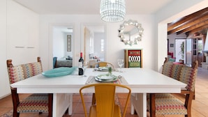 A dining area with a white table, yellow chairs, a chandelier, and a mirror on the wall. - Holiday Home 'Villa Floti With Sea View' with Sea Views, Wi-Fi and Air Conditioning (Telde)