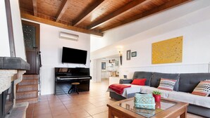 A living room with a sofa, a coffee table, a television, and a piano. - Holiday Home 'Villa Floti With Sea View' with Sea Views, Wi-Fi and Air Conditioning (Telde)