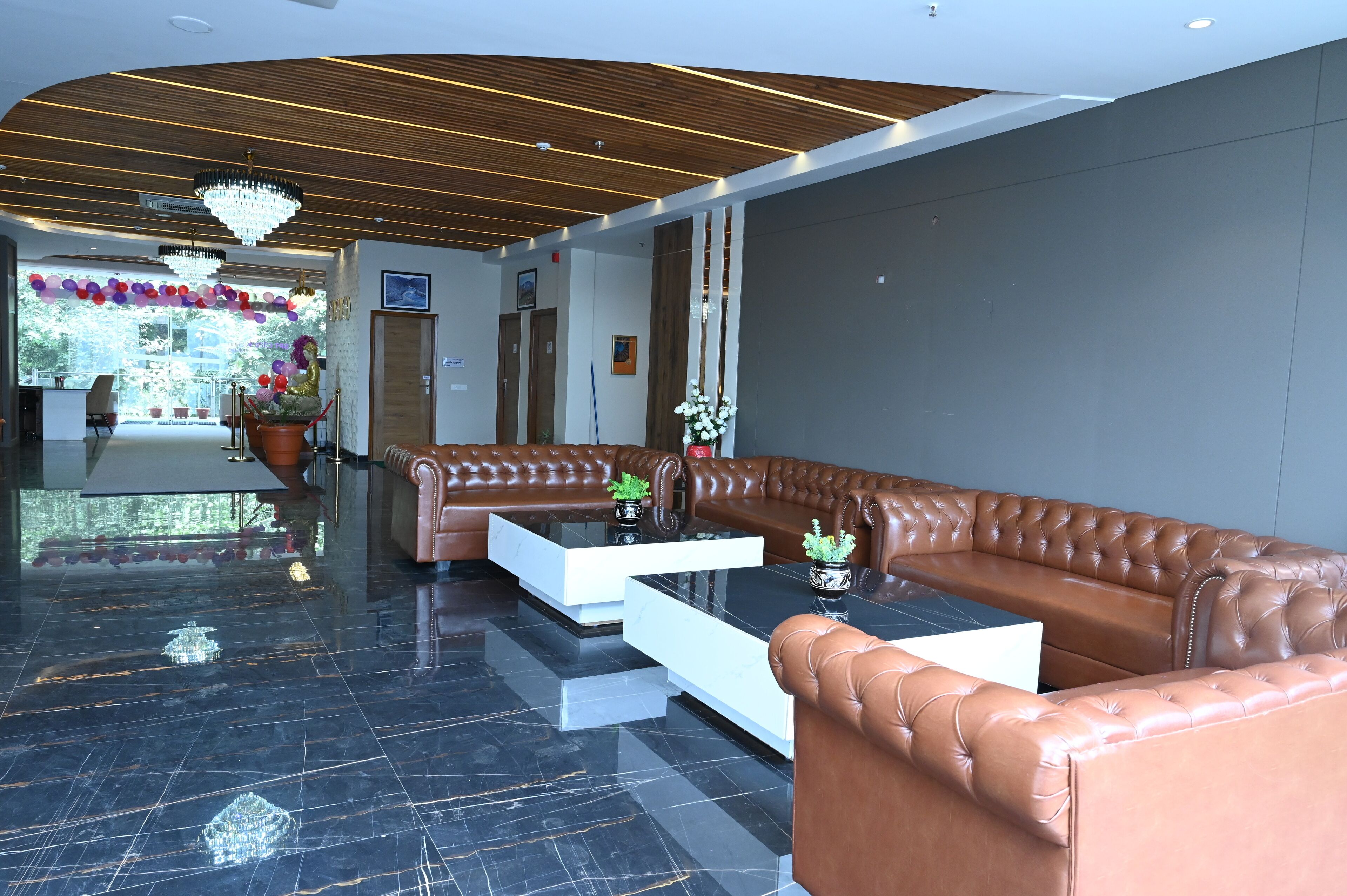 A modern lobby with leather sofas, a marble floor, and a wooden ceiling.
