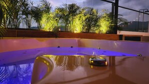 A swimming pool with a car on the water, surrounded by palm trees and a sunset view. - Luxury 4 /jacuzzi/terrace/private/cerca Al Poblado (Medellín)