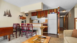 Un espace de vie compact comprenant un coin repas, une cuisine et un coin salon.