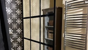 A room with a sliding door, a metal shelf unit, and a built-in towel rack. - Chez Caroline Ingalls (Gavray-sur-Sienne)