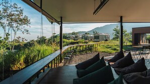 Un espace extérieur moderne aménagé avec des sièges et offrant une vue sur les maisons de montagne.