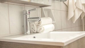 A bathroom with a white sink, chrome faucet, and a towel rack. - Fionia In Gazi- Athens Center Apartment Num3585 (Athens)
