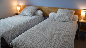 Two twin beds with matching patterned bedding, wooden headboards, and bedside lamps. - Charming Gîte with Garden and Child's Play Area - Near Altkirch Center (Altkirch)