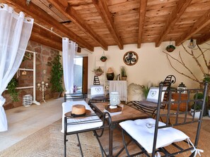 A rustic wooden ceiling, a stone wall, a bed with a white canopy, a table with a basket, and a chair with a white cushion. - Charming F2 in Alsace Vineyard, Cozy Comfort, Outdoor Space, Near Colmar & Mulhouse (Bergholtz)