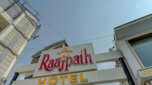 Das Eingangsschild des Raajpath Hotels mit modernem architektonischem Design.
