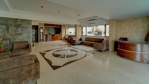 Eine großzügige Lobby mit einer Rezeption, Sofas und einem großen Teppich.