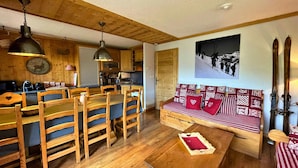 Ein gemütliches Blockhaus-Interieur mit Holzkunst, einem Essbereich, einer Küche und einer Wand mit Ski-Motiven.