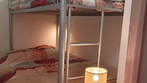 Ein Stockbett mit einer Lampe auf einem Nachttisch.