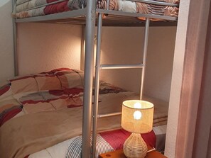 Un letto a castello con una lampada sul comodino.