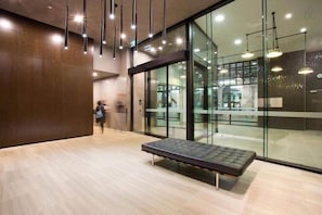 Ein modernes Interieur mit einer Bank, Glaswänden und Pendelleuchten.