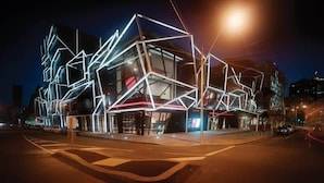 A modern building with geometric light installations at night. - Comfy & Stylish 2BR Apt Next to Crown, City Views (Southbank)