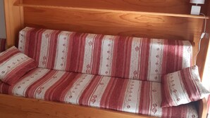 A wooden bench with a striped fabric cushion and a small lamp on a wooden shelf. - Cozy Studio for 4 with Balcony, Close to Slopes in Serre Chevalier (La Salle-les-Alpes)