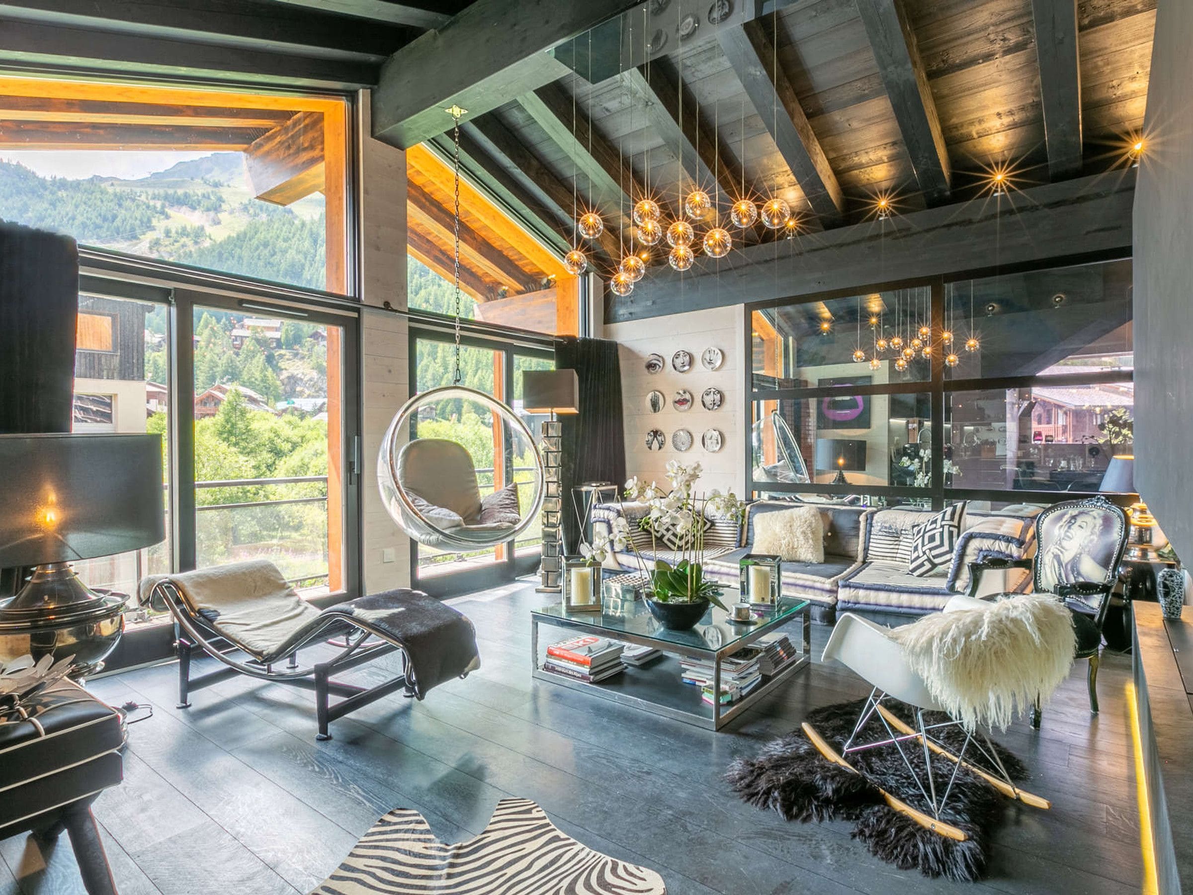 A spacious living room with a hanging chair, a sofa set, and a coffee table.