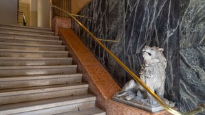 A marble staircase with a lion statue at the bottom. - Casa Gisella for a completely relaxing stay (Trieste)