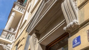 A building facade with classical architectural elements, including columns and ornate moldings. A blue sign with the number 6 and the text "VIA DI SCORCOLA" is visible. - Casa Gisella for a completely relaxing stay (Trieste)