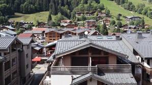 Un resort de montaña con edificios de estilo chalete, un telesilla y vistas del bosque circundante.