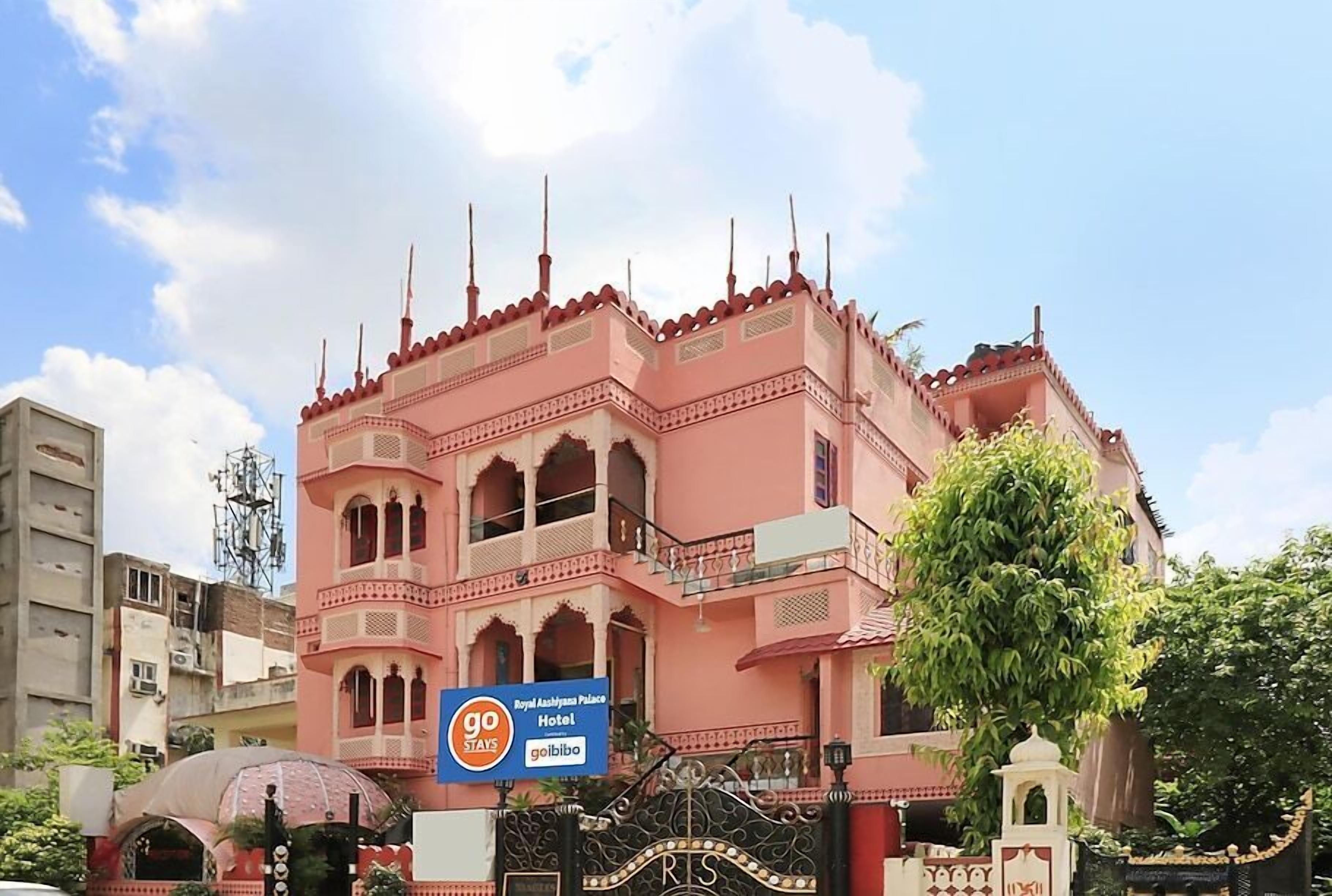 A pink building with a sign for the Royal Ashok Hotel.
