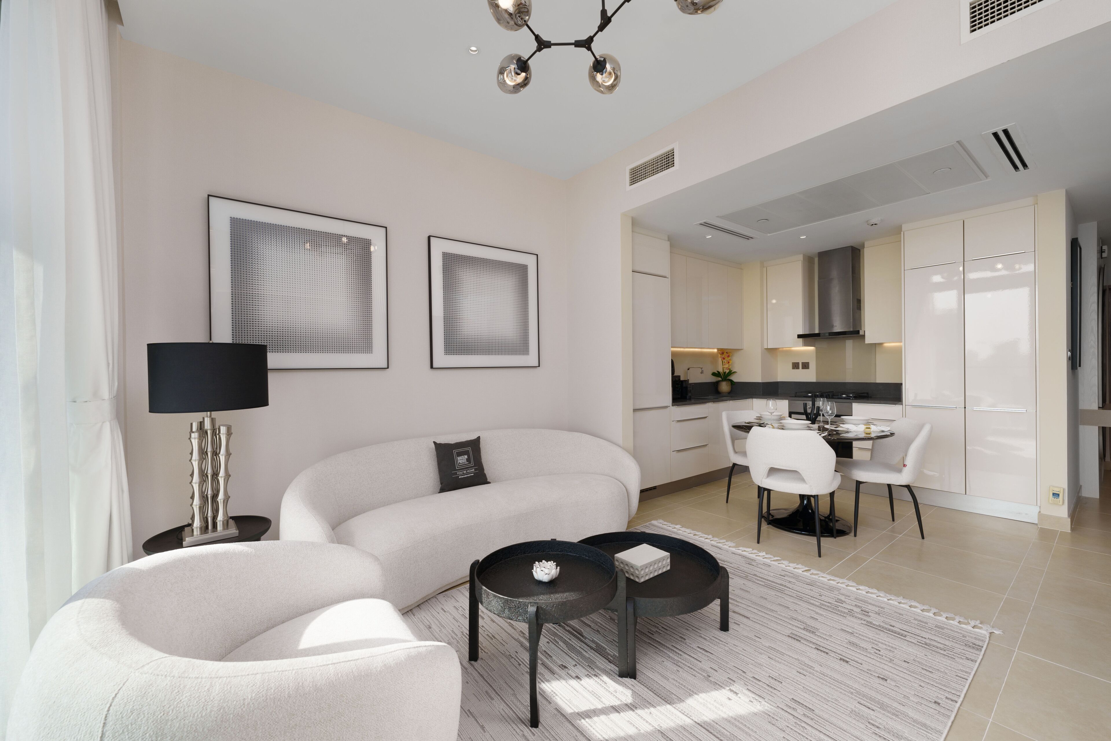 A modern living room with a sofa, two coffee tables, and a dining area with chairs.
