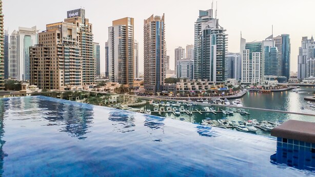 A cityscape with high-rise buildings and a marina with boats.