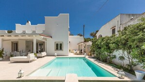 A modern house with a swimming pool, outdoor furniture, and a well-maintained garden. - 3512 Villa Mediterranea by Perle di Puglia (Ostuni)
