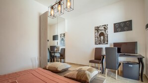 A modern hotel room with a bed, desk, chair, and a television. - 3512 Villa Mediterranea by Perle di Puglia (Ostuni)