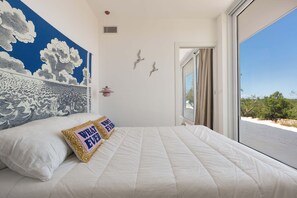 A bedroom with a large bed, a view of the beach, and a mural of clouds on the wall. - 3510 Villa Montipuglia by Perle di Puglia (Carovigno)