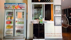 Un pequeño puesto de refrescos con un letrero que dice 'Fresh & Cool', repleto de diversas bebidas.