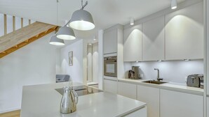 A modern kitchen with a central island, stainless steel appliances, and pendant lighting.