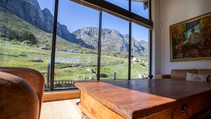 Una habitación con una mesa de madera, un sofá y un cuadro en la pared.