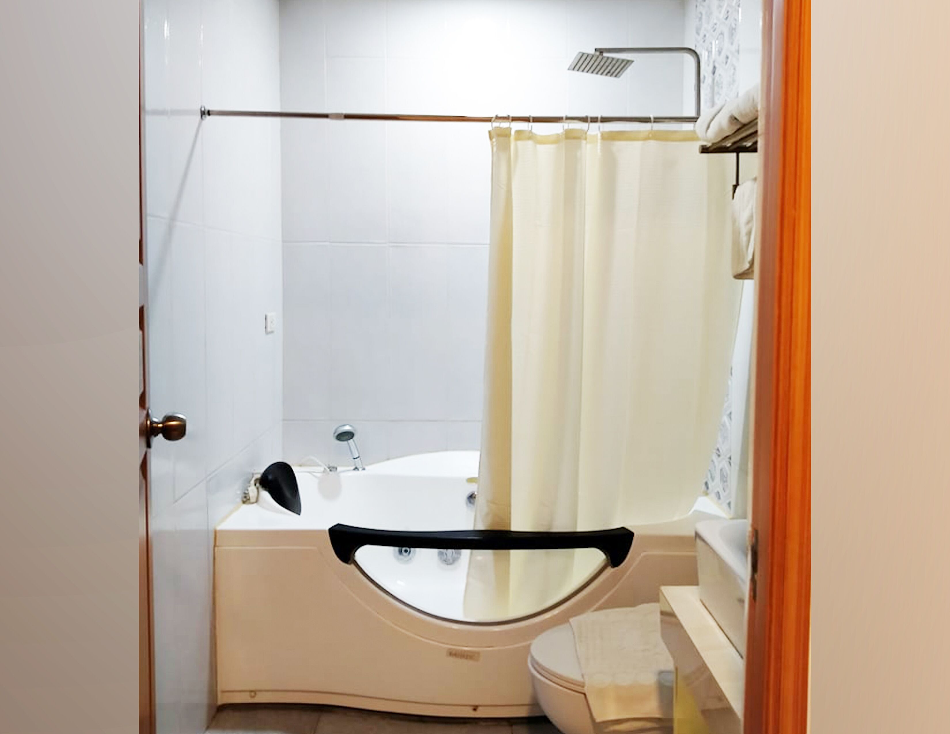 A bathroom with a bathtub, toilet, and shower area.