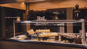 Vitrina de forn a La Cabane amb diferents productes de forneria i un rètol de neó a la part superior.