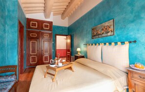 A bedroom with a bed, a wooden nightstand, a painting, and a door. - 6 bedroom nice home in Grosseto (Grosseto)