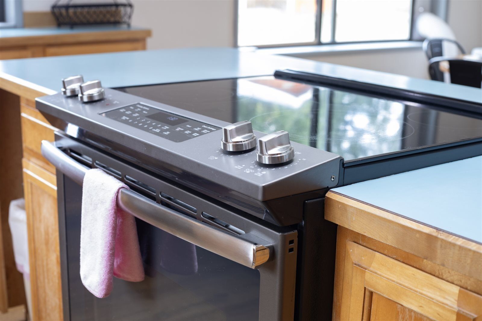 A modern kitchen with a built-in oven and stovetop, featuring a stainless steel finish and a glass backsplash.
