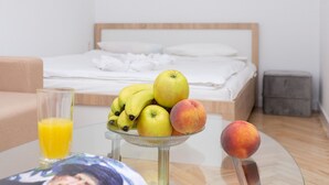 A hotel room with a bed, a glass of orange juice, and a bowl of fruit on a table. - Apartment in the heart of Minsk (Minsk)