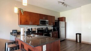 A modern kitchen with granite countertops, stainless steel appliances, and wooden cabinets.