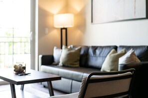 A modern living room with a sofa, a table, and a lamp.