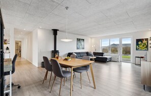 Enjoy a cozy atmosphere in this inviting space with a dining area, sleek stove, and comfortable sofa.
