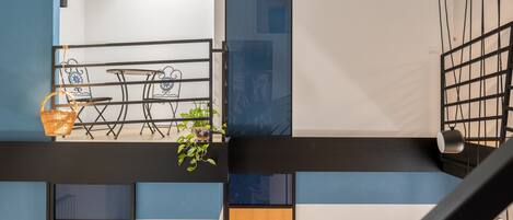 A modern interior with a dining area, a staircase, and a view of the outside.