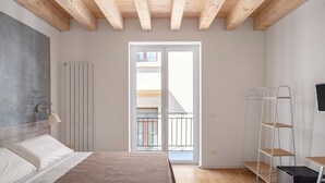 A bedroom with a bed, a radiator, a balcony, and a shelving unit. - Le Stanze di Triyah (Palermo)