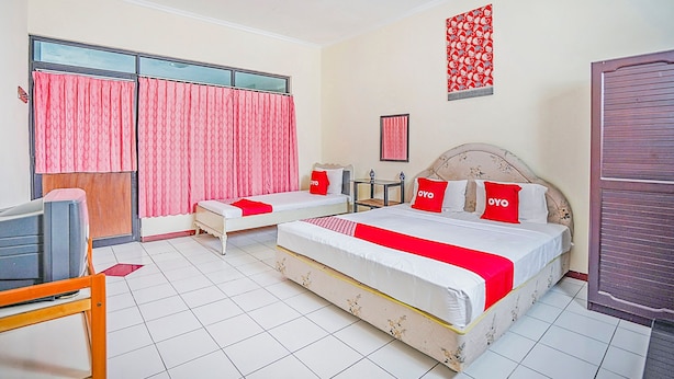 A hotel room with two beds, a desk, and a TV. - Hotel O Lie Mas Hotel (Prigen)