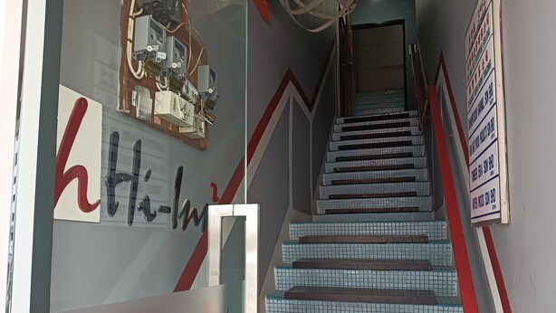 A staircase with a red and white striped handrail, leading to an upper floor. - Hotel O Hi Inn 2 (Sibu)