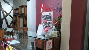 A reception desk with a glass top, wooden shelves, and a sign indicating free Wi-Fi. - Hotel O Hi Inn 2 (Sibu)