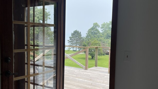 Una habitación con un amplio ventanal corredero que da a una terraza exterior.