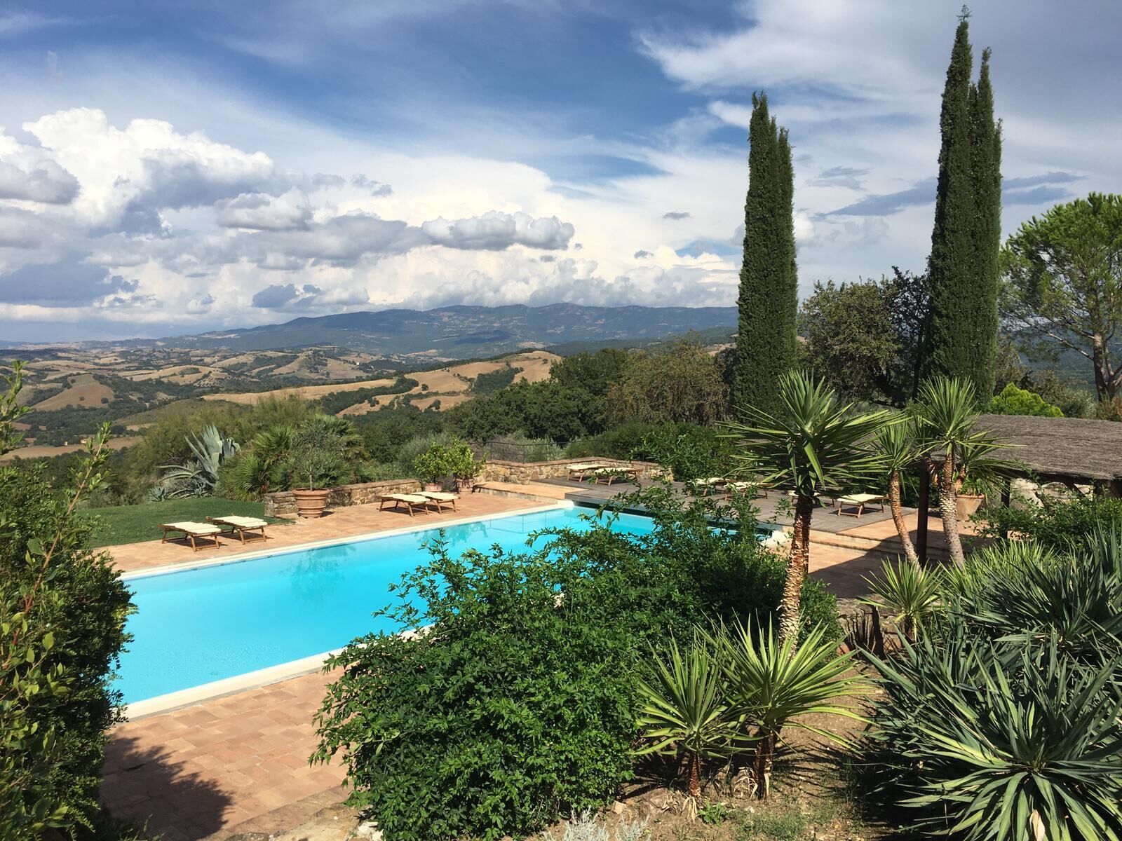 A pool with a view of rolling hills and a clear sky.